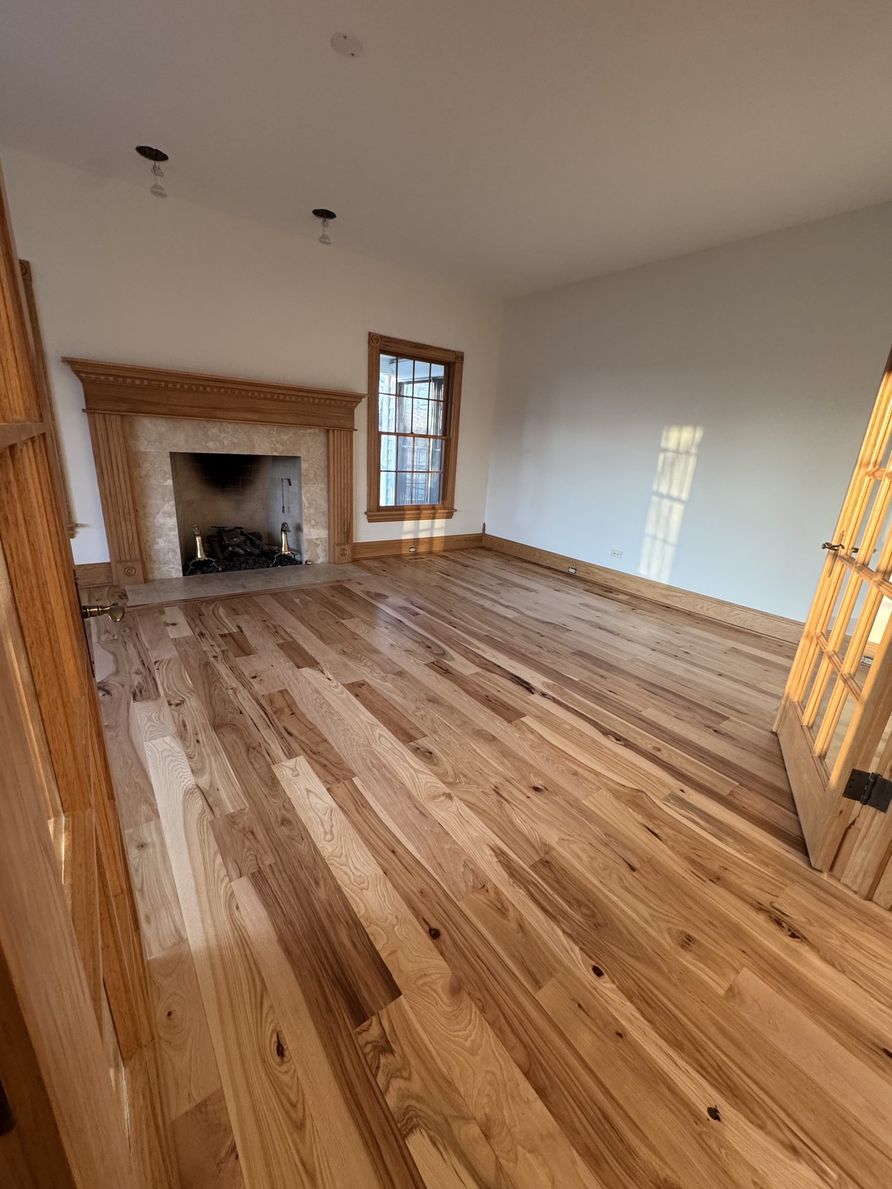 Formal sitting room wide plank hickory with fireplace mantel